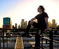 a man sitting on a railing with a guitar